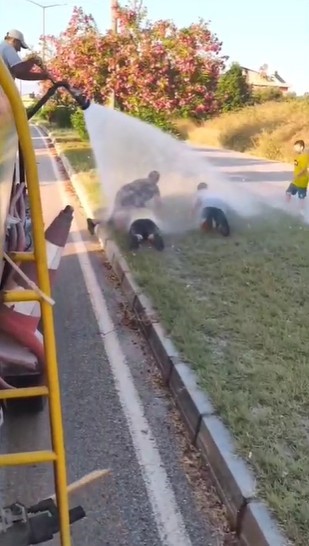 Sıcaktan bunalan çocuklar refüjde sulama yapan su tankeriyle serinledi 