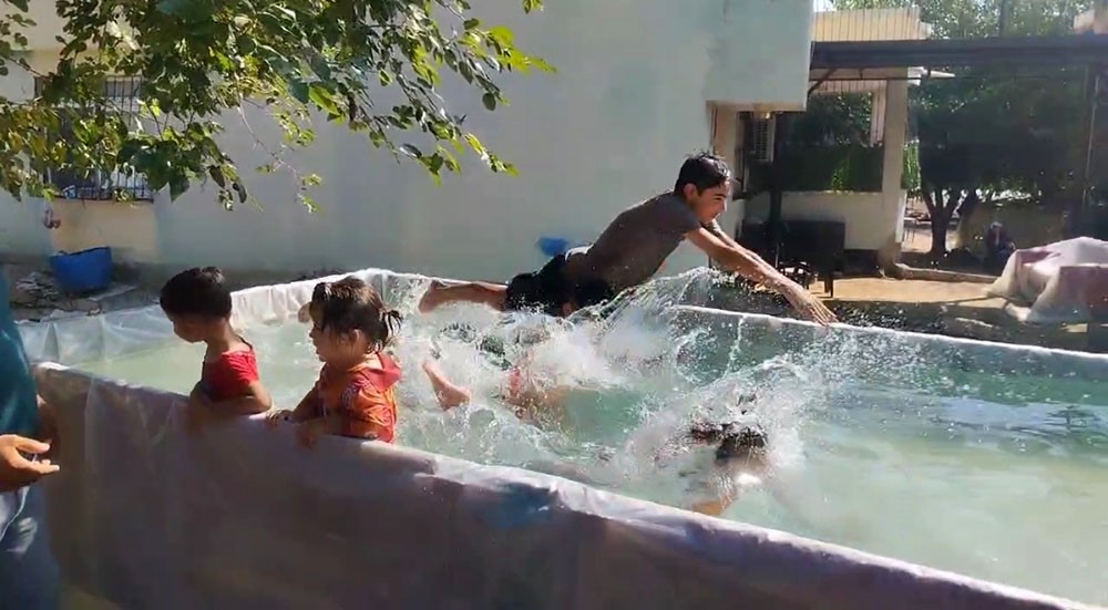 Sıcaktan denize giremeyen çocuklara römorkta havuz yaptı 