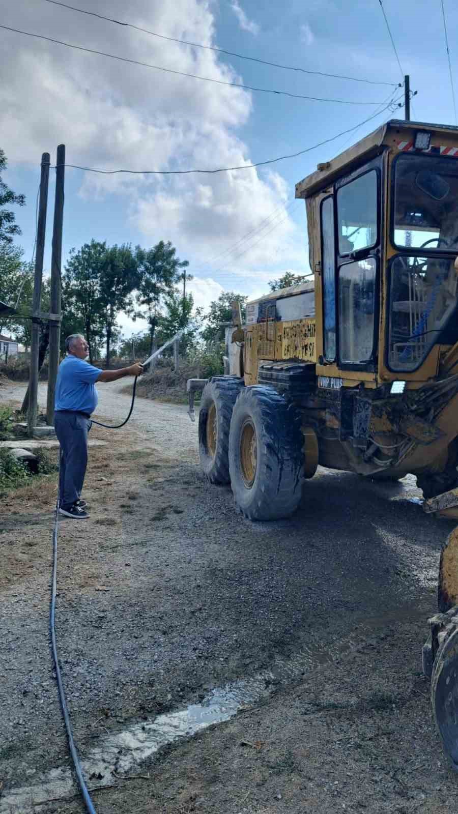 Muhtar, yol çalışması yapan iş makinesini kendi elleriyle yıkadı 